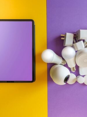 A collection of smart home devices beside a blank tablet on yellow and purple background.
